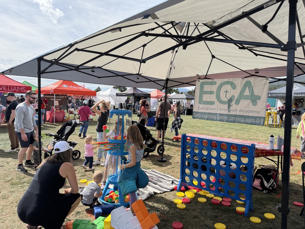 Kids playing giant Connect Four and a ball tower at the ECA booth