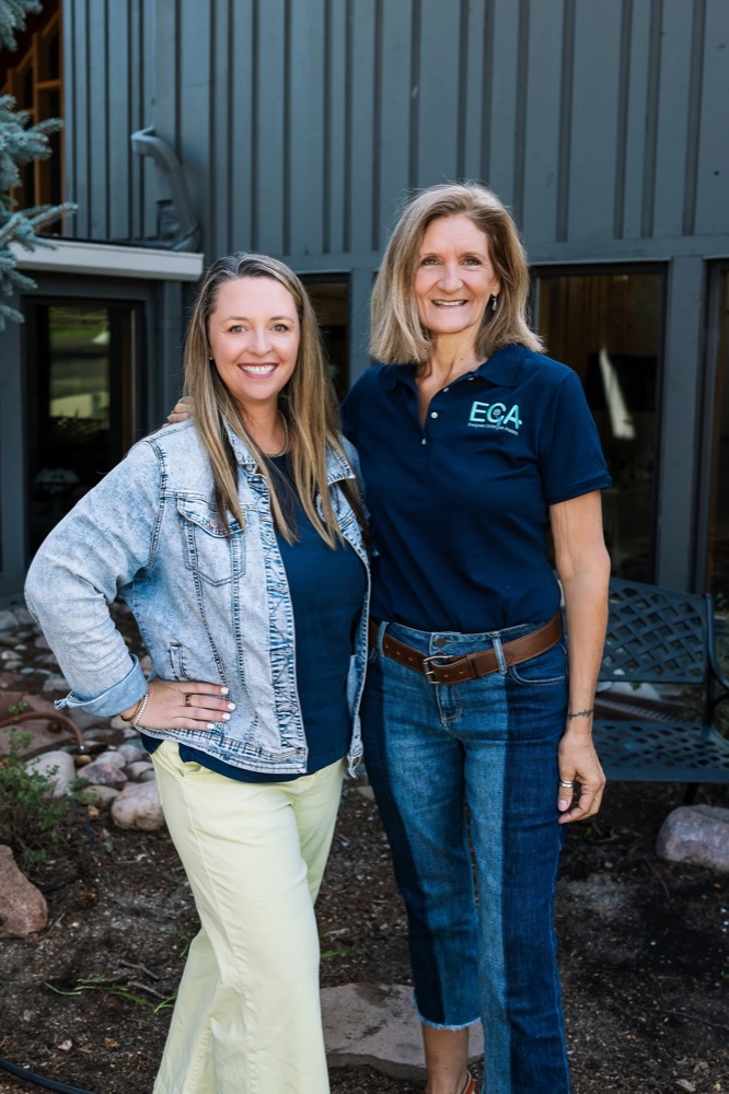 Lauren Anderson and Lisa Thoennes standing together outside the school